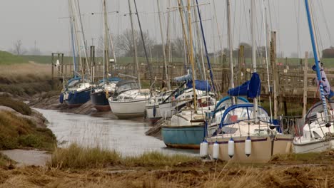 Gesamtaufnahme-Mehrerer-Yachten,-Die-Am-Steil-Abfallenden-Fluss-Am-Gibraltar-Point-Festgemacht-Haben,-Wobei-Bei-Ebbe-Schlammbänke-Sichtbar-Sind