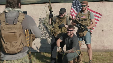 military men taking photo with guns