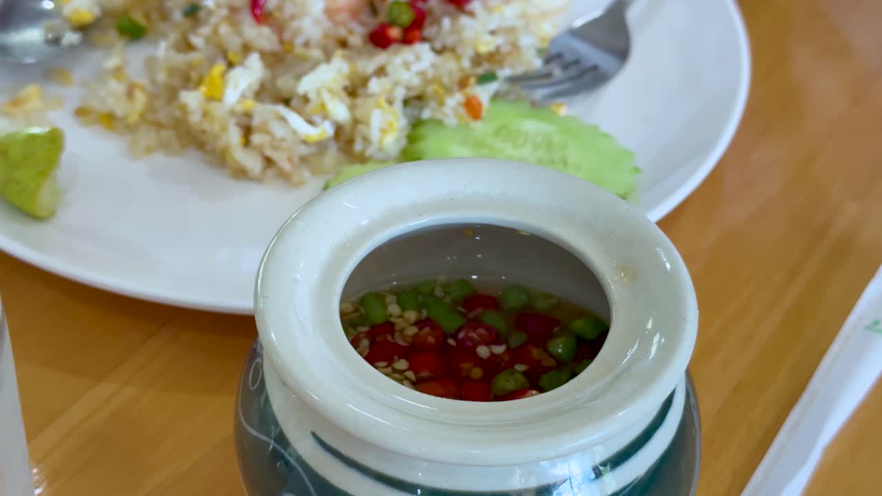 sirviendo salsa de pescado picante sobre arroz frito