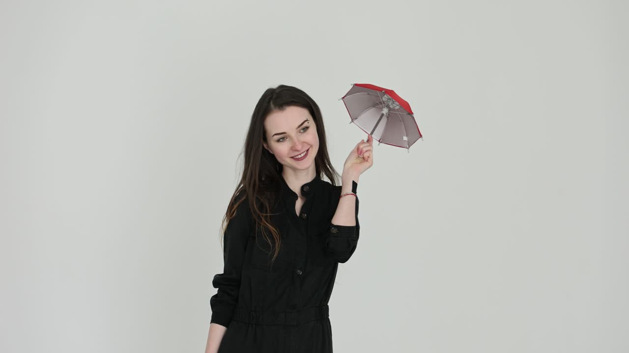 Woman Posing with a Small Red Umbrella on a White Background