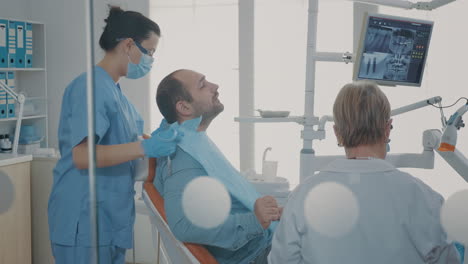 dentist showing teeth radiography to patient on dental chair