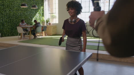 jóvenes hombres de negocios negros jugando al ping pong en la oficina disfrutando de la diversión competitiva colega usando el teléfono inteligente compartiendo el juego en las redes sociales tomando video