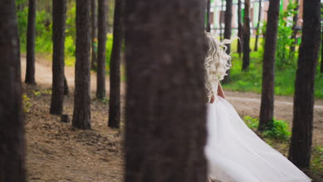 attractive curly haired lady bride runs along pine forest