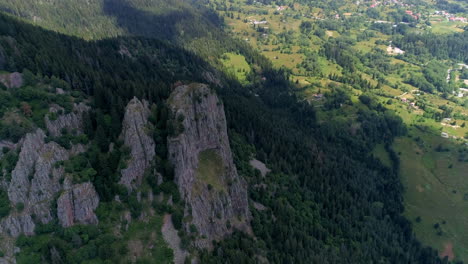 aerial view of majestic rocky mountains and lush forests overlooking a valley village