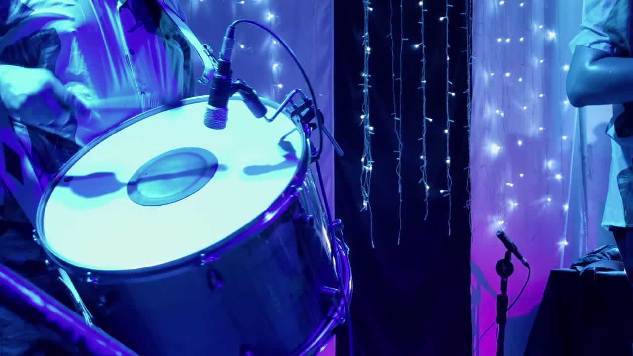 4K close-up of a zabumba player performing forró at a lively party. The rhythmic drumbeats, combined with warm stage lights, capture the essence of Brazilian folk music and cultural celebration.