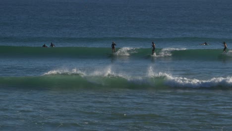 surfistas cabalgando sobre las olas azules en la playa de snapper rocks - aventura de surf en gold coast, queensland, australia - plano general