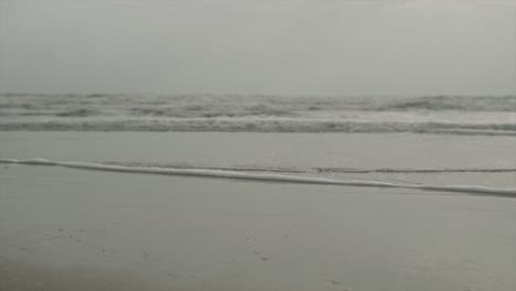 beach shore with pebbles, sand on the sunset with waves crashing