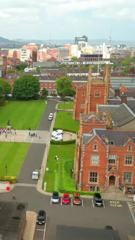 advancing, side-on social ratio aerial video of queen's university, belfast on a bright and sunny day. filmed in 1080x1920, 60fps and with rec709 color