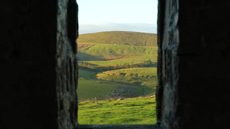 Scenic countryside view from narrow lookout inside ancient stone tower