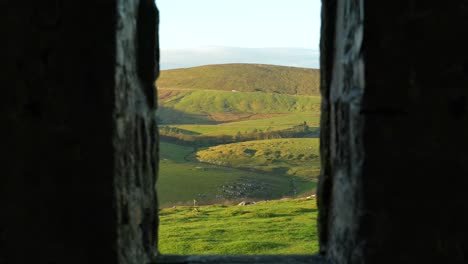 Scenic-countryside-view-from-narrow-lookout-inside-ancient-stone-tower