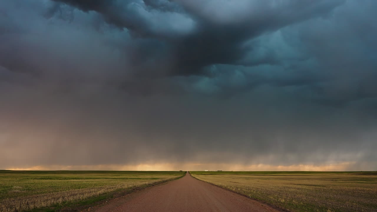 Stormfuldt landskab med lyn over en landevej