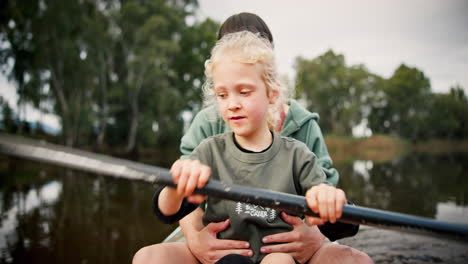 Mother,-girl-and-rowing-kayak-in-lake-on-holiday