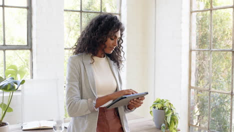 professional woman using tablet in bright office, focusing on work, at home office