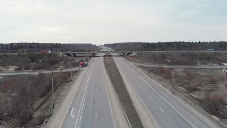 автомобильный перекресток с мостом на облачном весеннем вечере в лесу