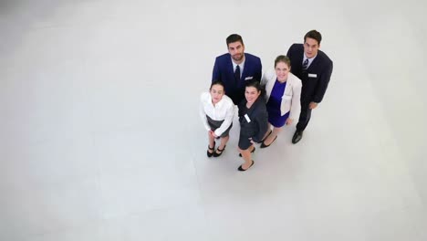 smiling businesspeople showing thumbs up in office