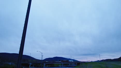 overcast sky over a rural highway with semi trucks traveling, showcasing the trucking industry's role in logistics and transportation