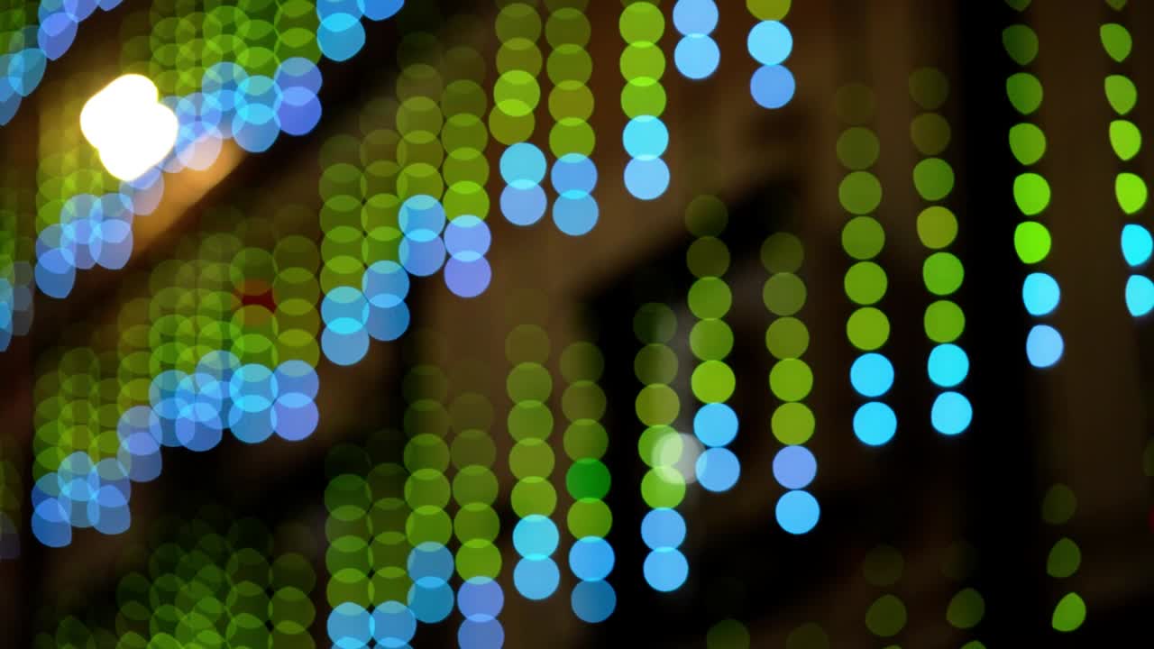 Abstract colorful bokeh lights video with defocused serial lighting. Soft blurred blue and cyan circles create a modern glowing background, ideal for creative motion graphics and elegant overlays