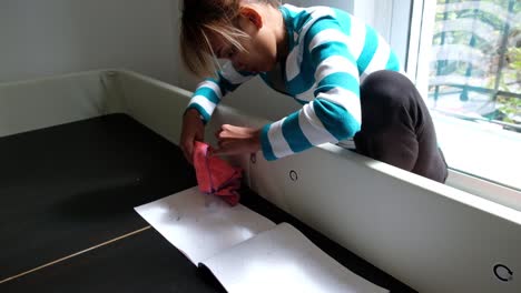 chica asiática está usando un trozo de tela y un tornillo hexagonal para atornillar una cama