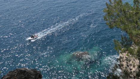 view over a cliff above blue sea and boat passing by, mediterranean