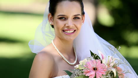 Beautiful-bride-smiling-at-camera-in-the-park