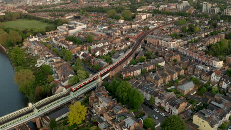 Toma-Aérea-Del-Tren-Subterráneo-De-La-Línea-De-Distrito-Que-Serpentea-A-Través-Del-Barrio-De-Putney,-Londres