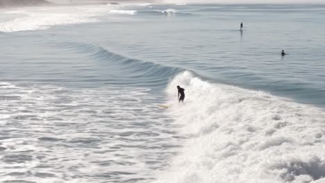 A beautiful aerial drone shot, drone tracking a surfer surfing a wave close to the beach, Carlsbad State Beach - California