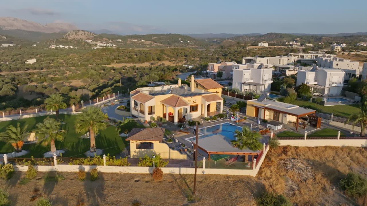 Drone flying around deluxe holiday villas, serene sunrise in Rhodes, Greece