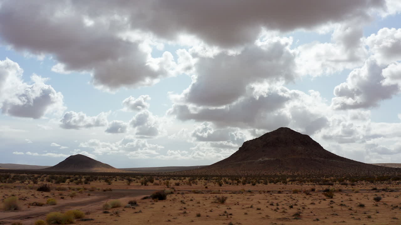 La tranquilla terra arida del deserto del Mojave in California con alcune montagne in lontananza - Ripresa aerea bassa