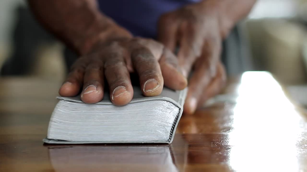 hombre orando a dios con la mano en la biblia con la gente stock video stock footage