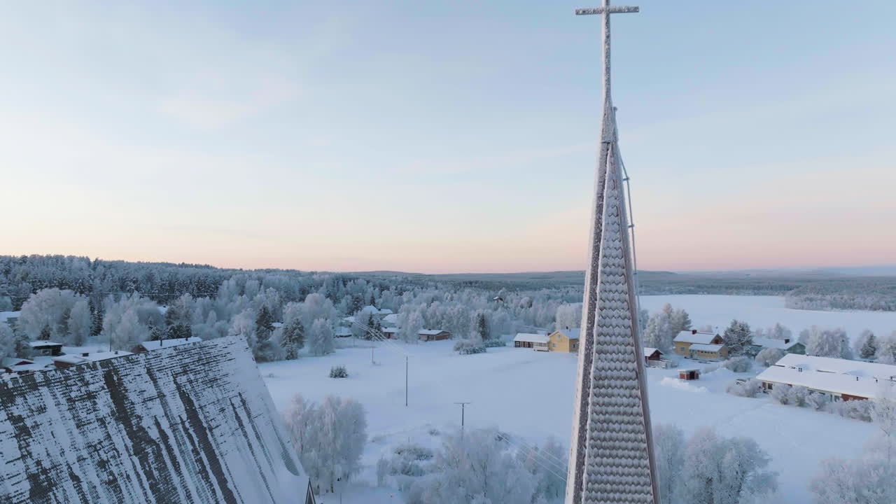 Aerial view rising around a icy cross on a church tower, polar night in Lapland