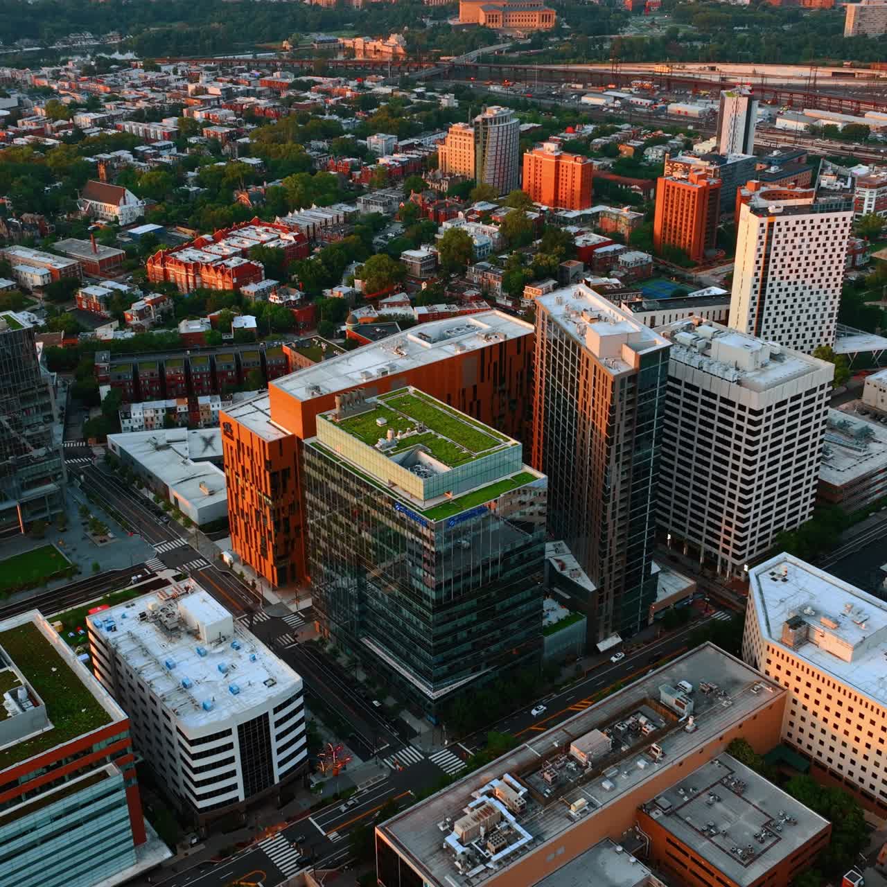 Roofs of Philadelphia buildings with green plantations on. Drone footage above the city scenery at daytime