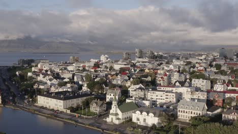 City-skyline-of-Reykjavik-in-Iceland-during-sunset,-golden-hour,-aerial