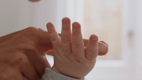 close up mother holding baby hand touching fingers nurturing newborn caring for infant enjoying motherhood connection with child