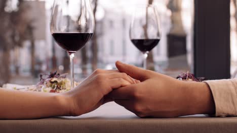 una pareja de manos en un restaurante.