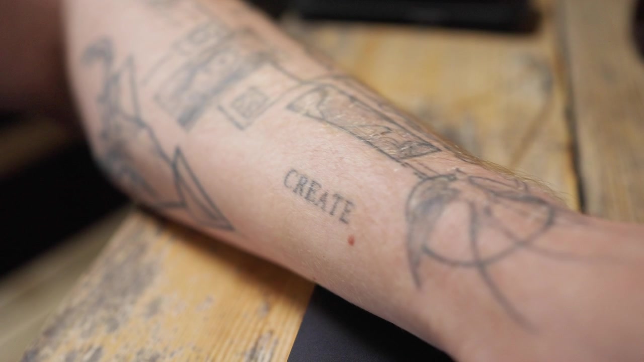 Primer plano de la mano de un empresario con un tatuaje de palabra visible
