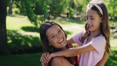 Mother-embracing-her-daughter-in-the-park