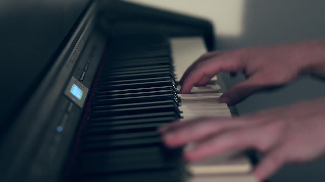 manos que se mueven rápidamente tocando el piano digital