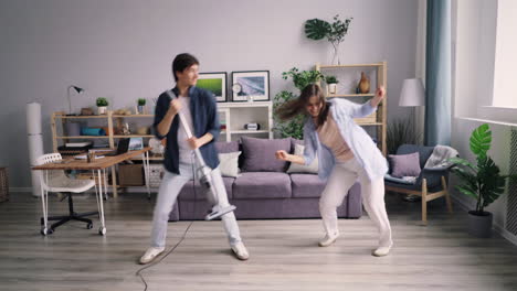 couple cleaning and dancing