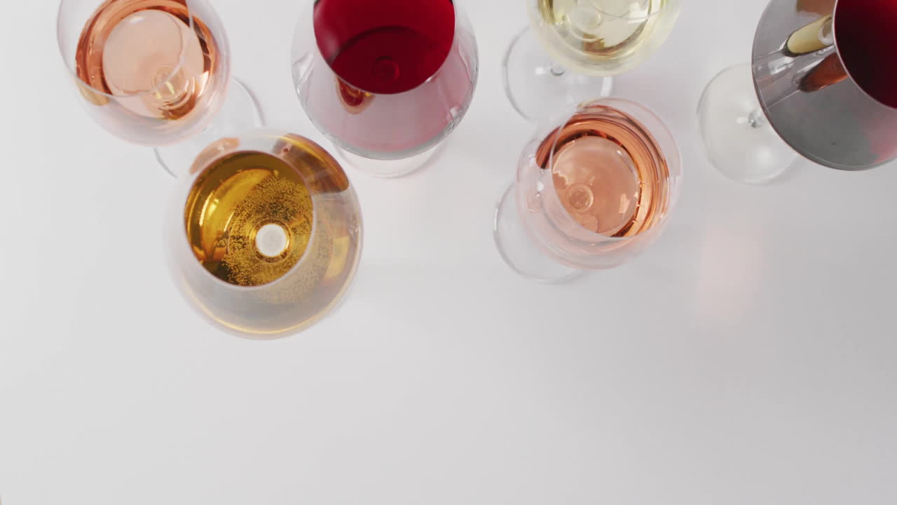 Composizione di bicchieri multicolori con vino rosso, rosato e bianco su sfondo bianco