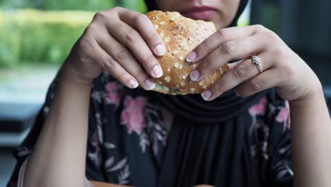 una mujer comiendo un sándwich.