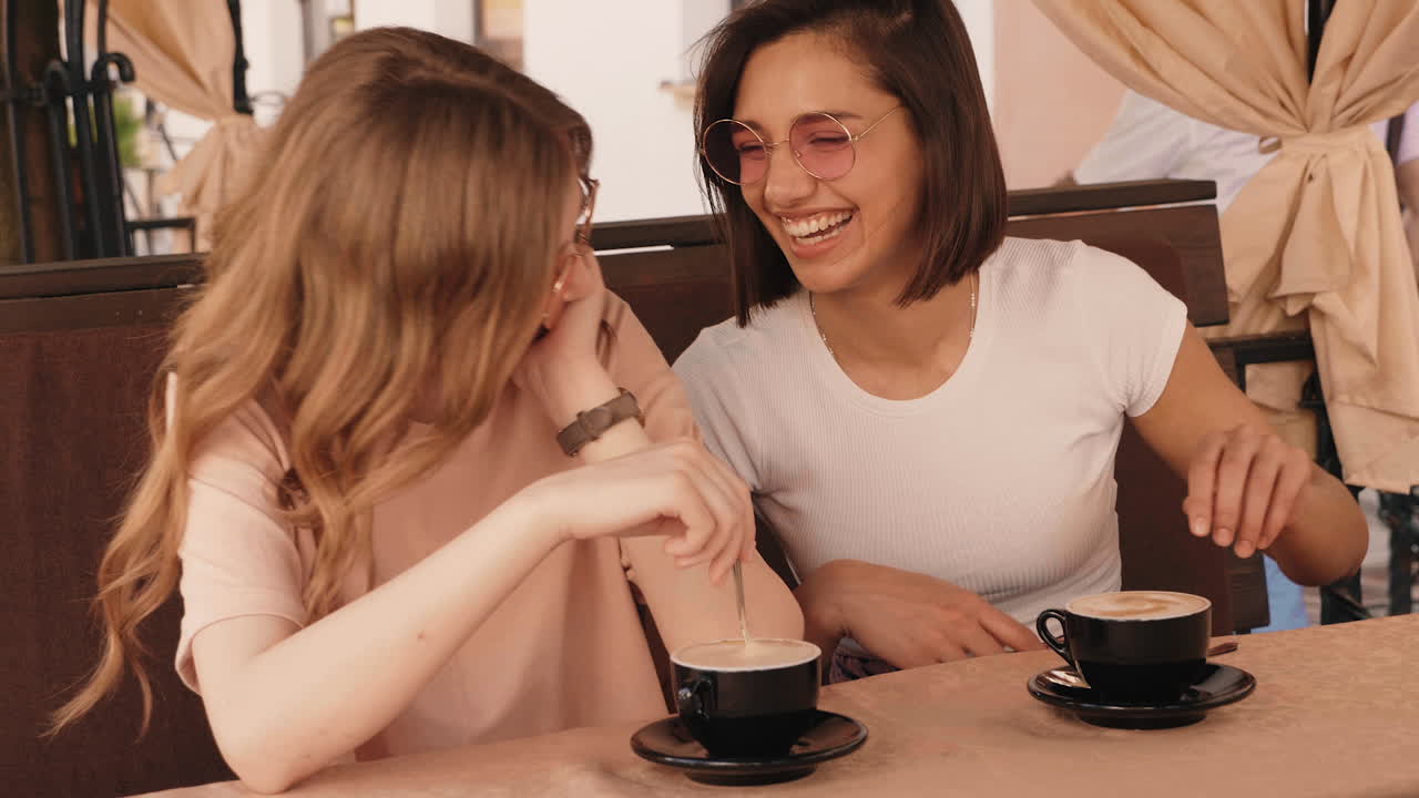 두 친구 가 야외 에서 커피 를 마시고 있다