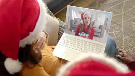 happy diverse couple and female friend having christmas laptop video call, slow motion