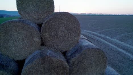 las balas de heno, apiladas en una pirámide, secas en el campo al atardecer.