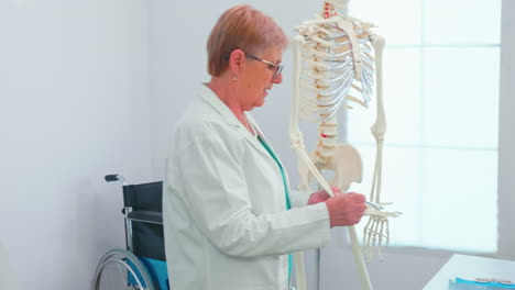 médica mujer enseñando anatomía usando esqueleto humano