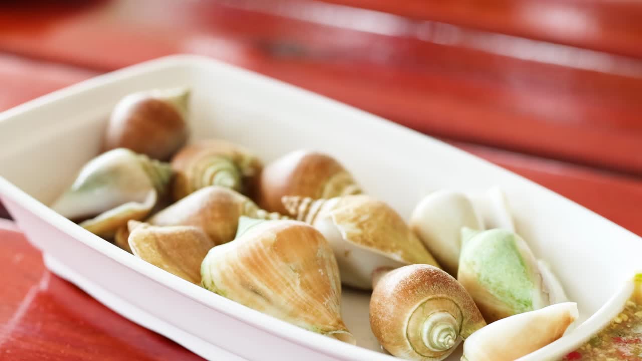 빨간 테이블 에 해산물 요리 를 제공 하는 손