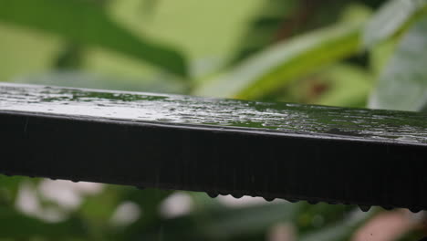 Gotas-De-Lluvia-Golpeando-Una-Baranda-De-Madera-Con-Un-Chapoteo---Primer-Plano