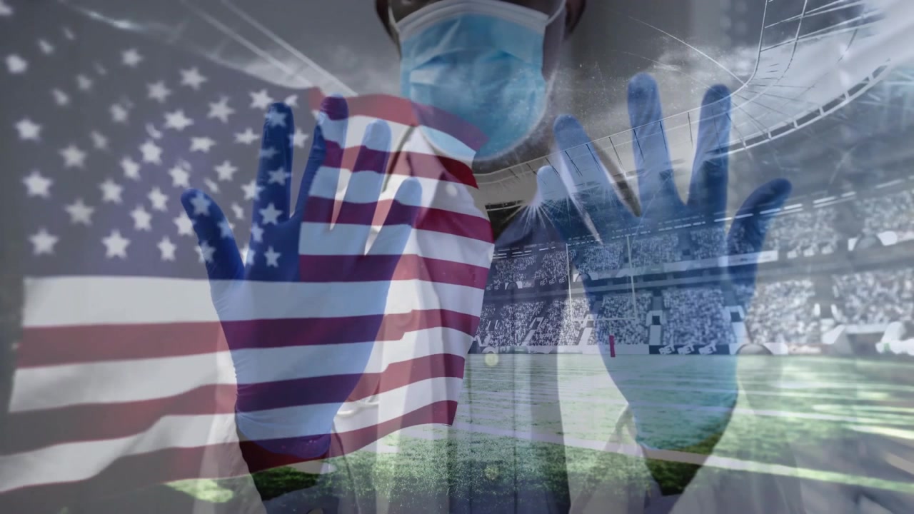 Healthcare worker raising gloves as American flag overlay sweeping torso honoring care in stadium