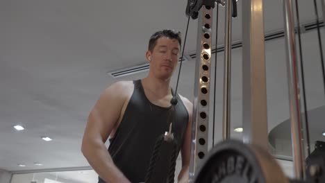 a man working out in the gym using a cable machine, focusing on upper-body strength training. concept of fitness, health, and physical activity.
