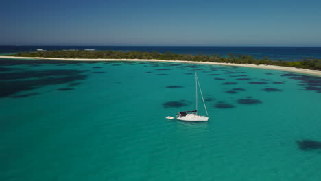 sailboat anchored off tropical island near isle of pines