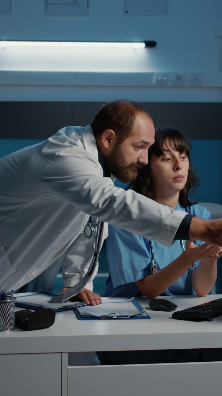 Vertical video: Nurse standing at desk showing medical expertise to physician doctor